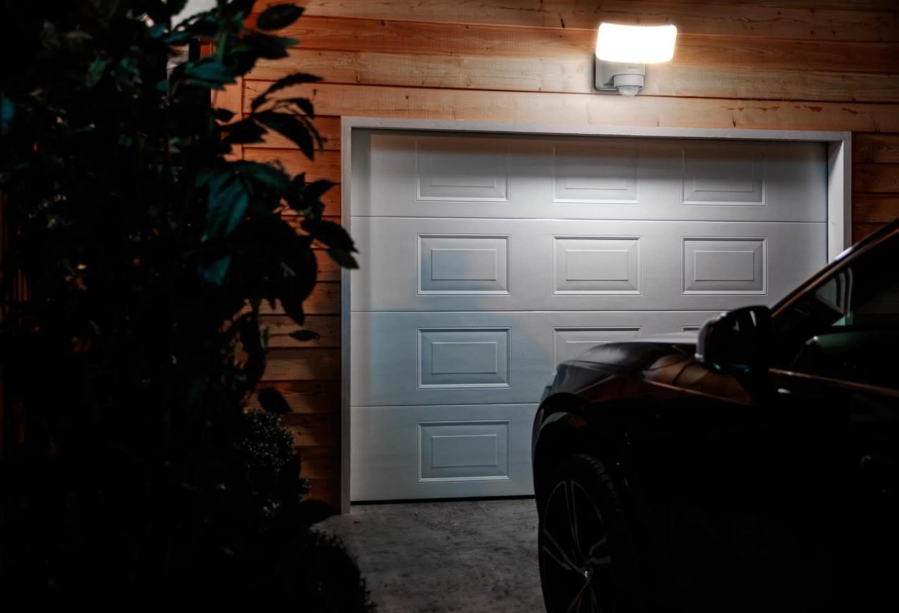 lampada led solare philips montata su parete esterna illumina un garage di notte per sicurezza