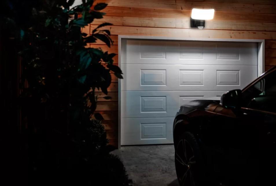 lampada led solare philips montata su parete esterna illumina un garage di notte per sicurezza