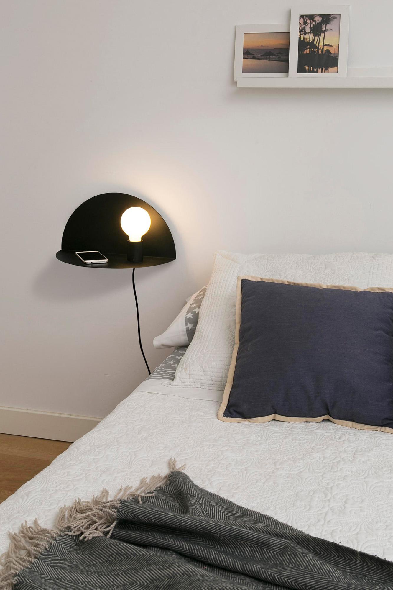 applique da parete nera con ripiano in ambiente camera da letto