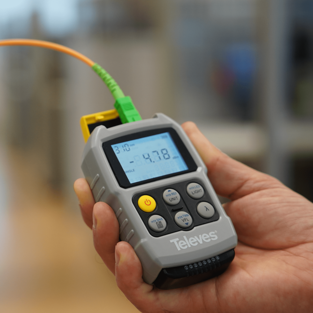 vista frontale del tester Televes per fibra ottica e RJ45 con display acceso e tasti funzione visibili