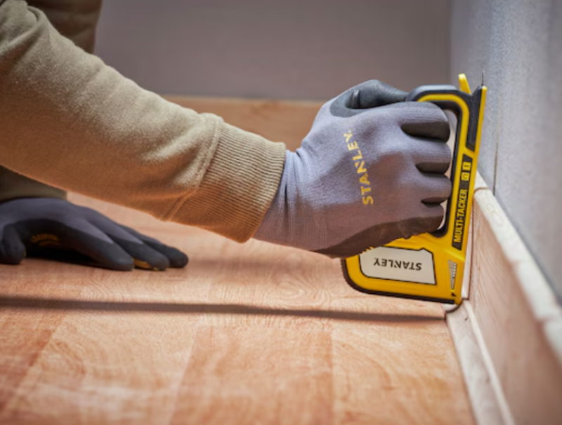 utilizzo graffatrice manuale Stanley per fissaggio battiscopa su pavimento legno