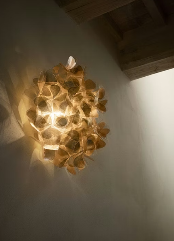 plafoniera da parete slamp clizia oro accesa in ambiente