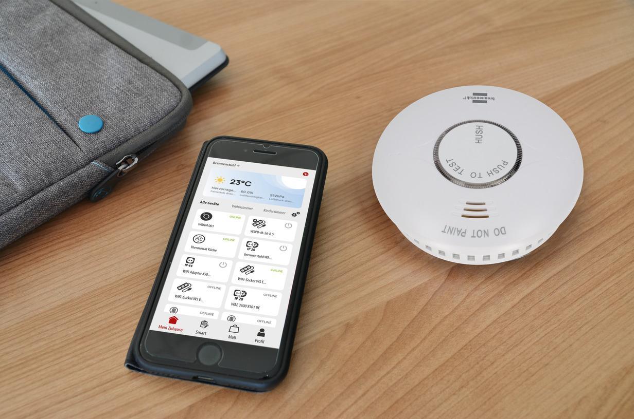 rilevatore di fumo wifi con smartphone e app brennenstuhl connect su tavolo